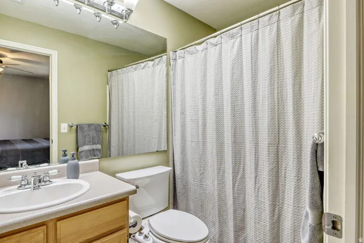 Bathroom featuring a vanity with a white sink, light-toned countertop, and wood-finish cabinetry