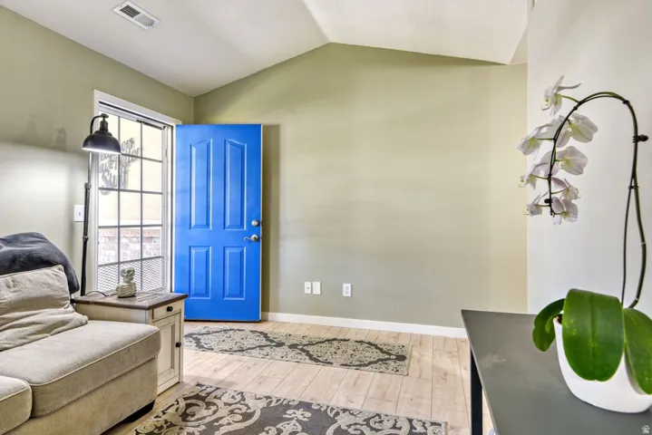 Entryway featuring a paneled blue door, light wood-finish flooring, and a large window with grid panes