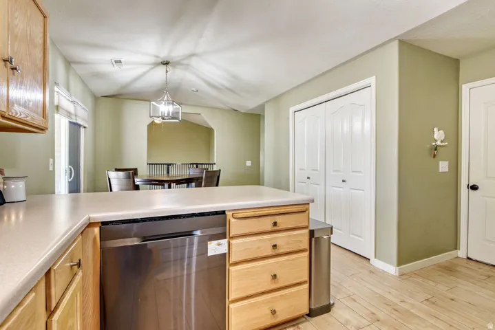 Kitchen island with a light-toned countertop and natural wood-finish cabinetry