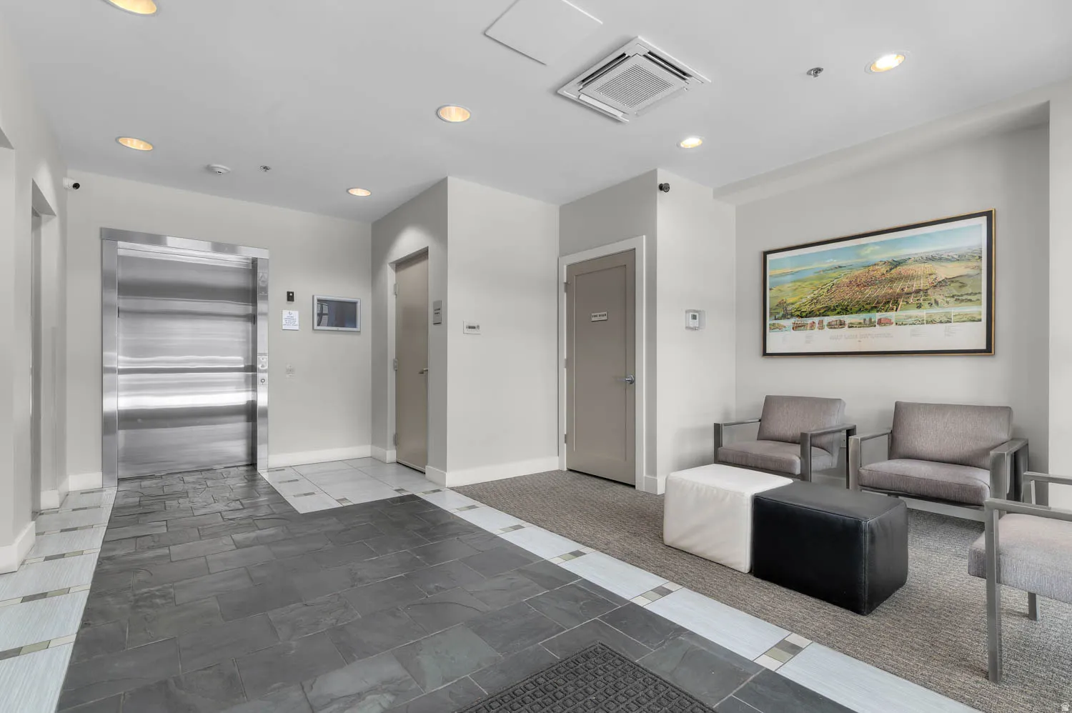 Lobby area featuring mixed material flooring with dark slate-style tiles and patterned light tiles
