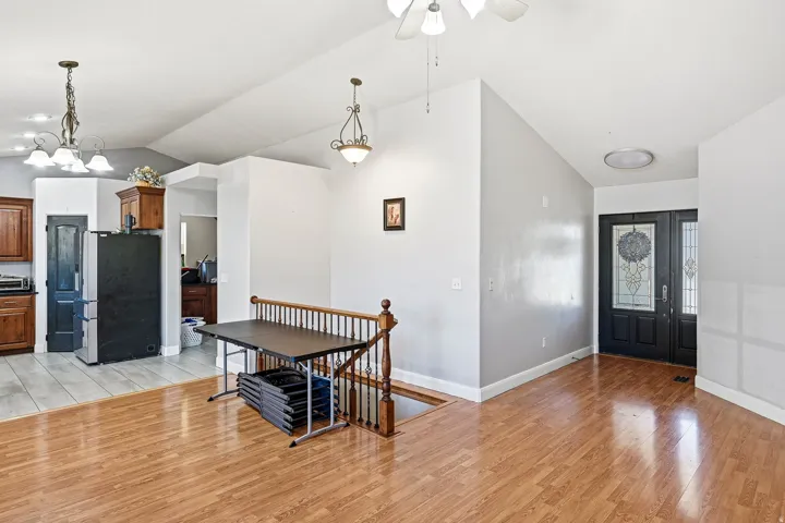 Inviting entryway featuring double doors with decorative glass panels and a vaulted ceiling