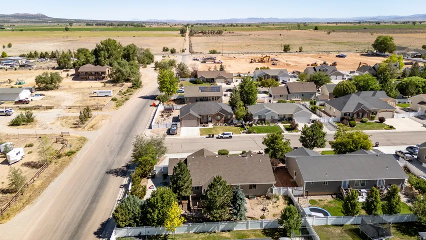 Aerial overview of a residential neighborhood with single-story and two-story homes, featuring established landscaping and paved streets