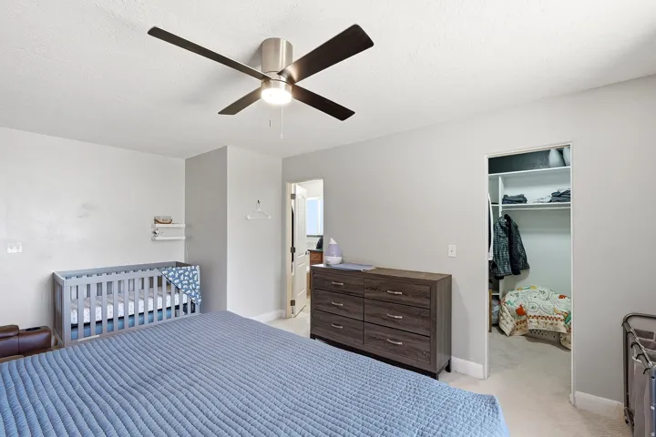 Bedroom featuring light gray walls and a ceiling fan with integrated lighting