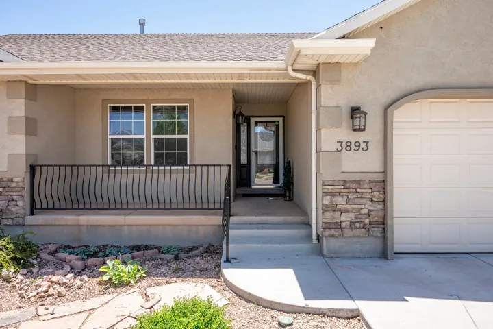 Stucco exterior with stone accents and a covered front entry