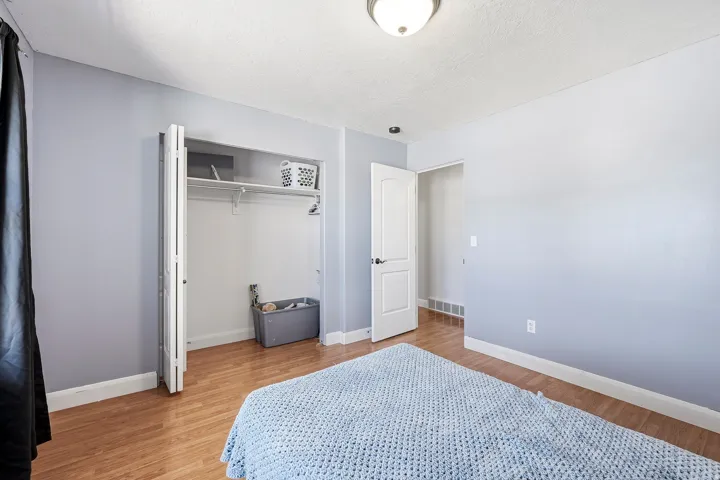 Bedroom featuring wood-finish flooring, a bi-fold closet, and a ceiling-mounted light fixture