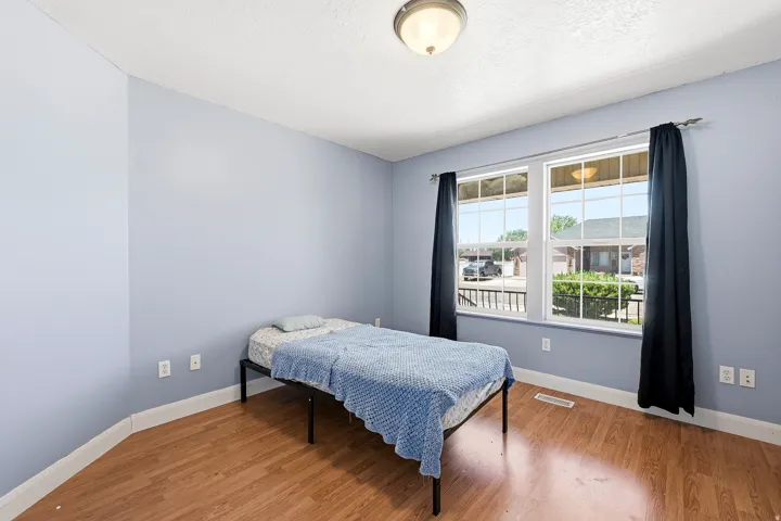Interior space featuring wood-finish flooring, light blue wall paint, white trim, and a ceiling-mounted light fixture