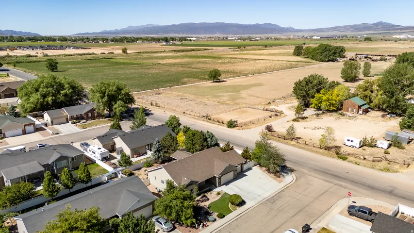 Aerial perspective showcasing a residential neighborhood bordering expansive open land