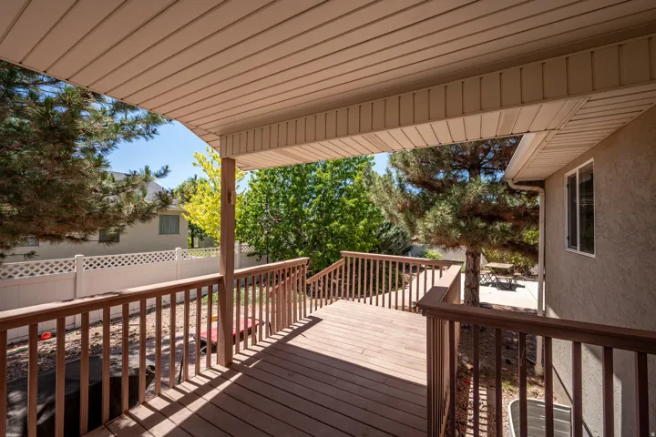 Covered deck featuring wood-finish flooring, wood railings, and a solid overhead covering