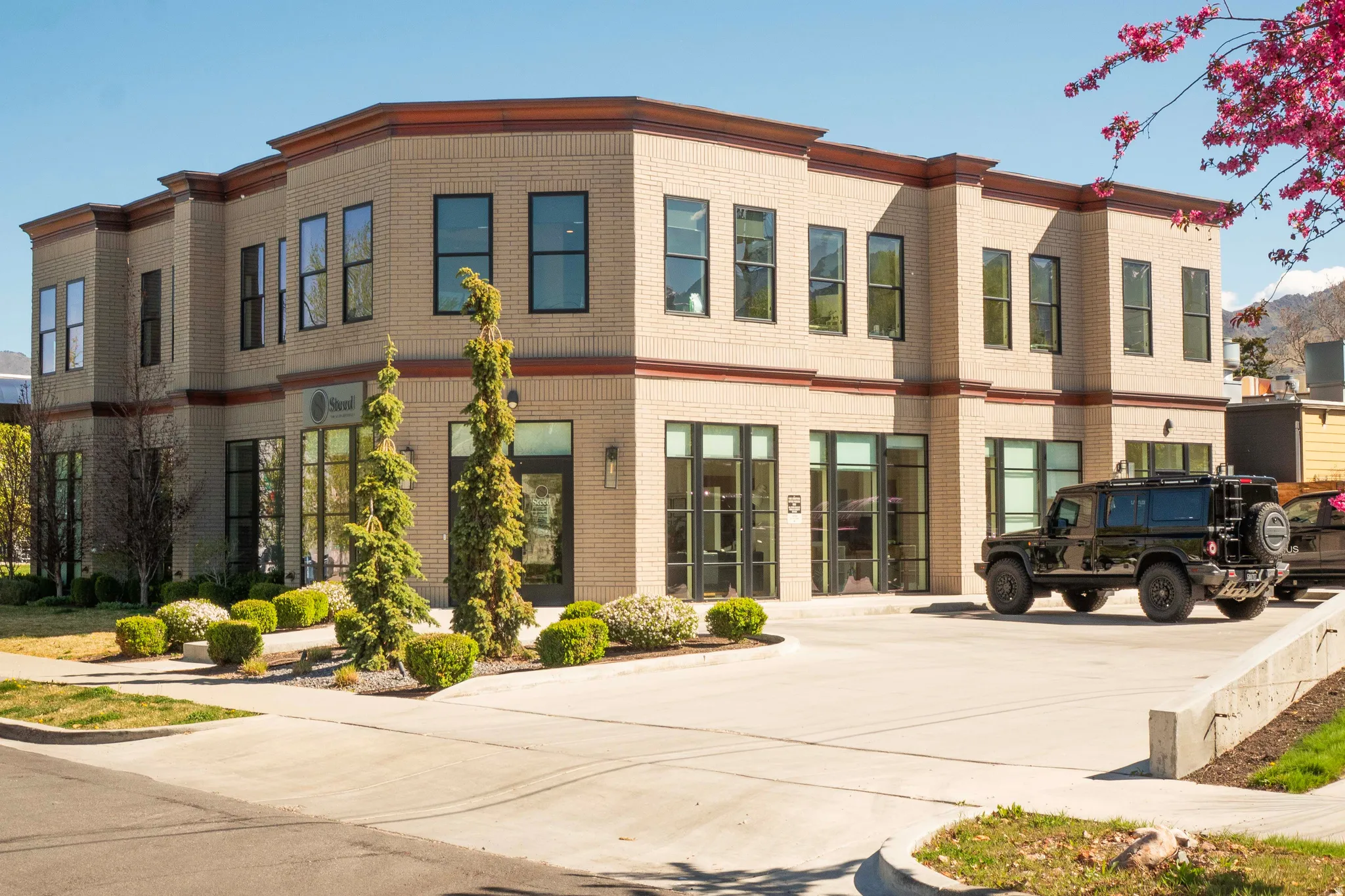 Contemporary commercial building featuring light-colored brick facade and dark trim accents