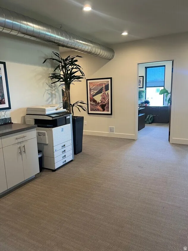 Interior space featuring neutral tone carpet flooring and recessed ceiling lighting