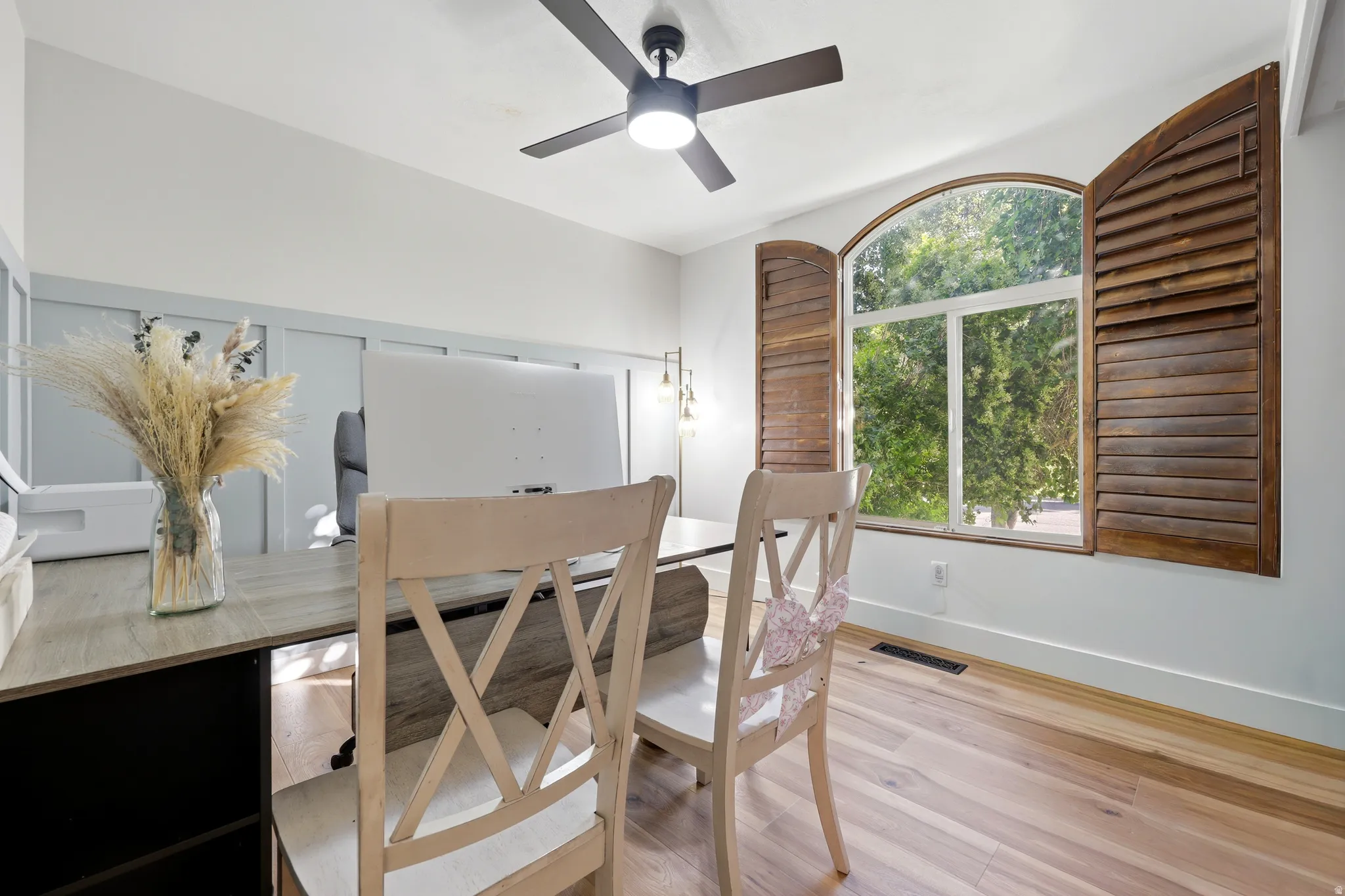 Arched window with wood-louvered shutters