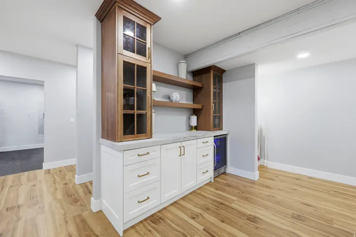 Built-in cabinetry featuring a beverage refrigerator, wood-finish shelving, and a light-toned countertop