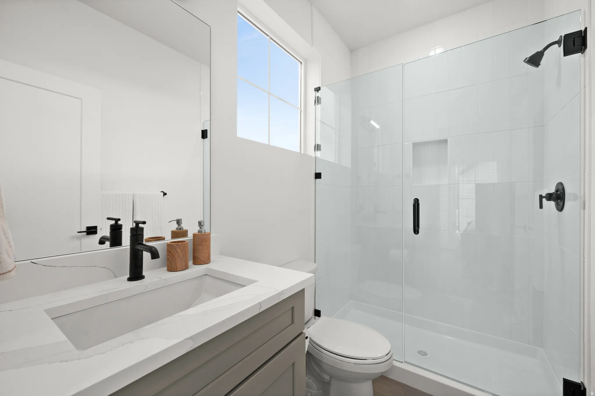 Bathroom featuring a white rectangular undermount sink, quartz countertop, and matte black faucet