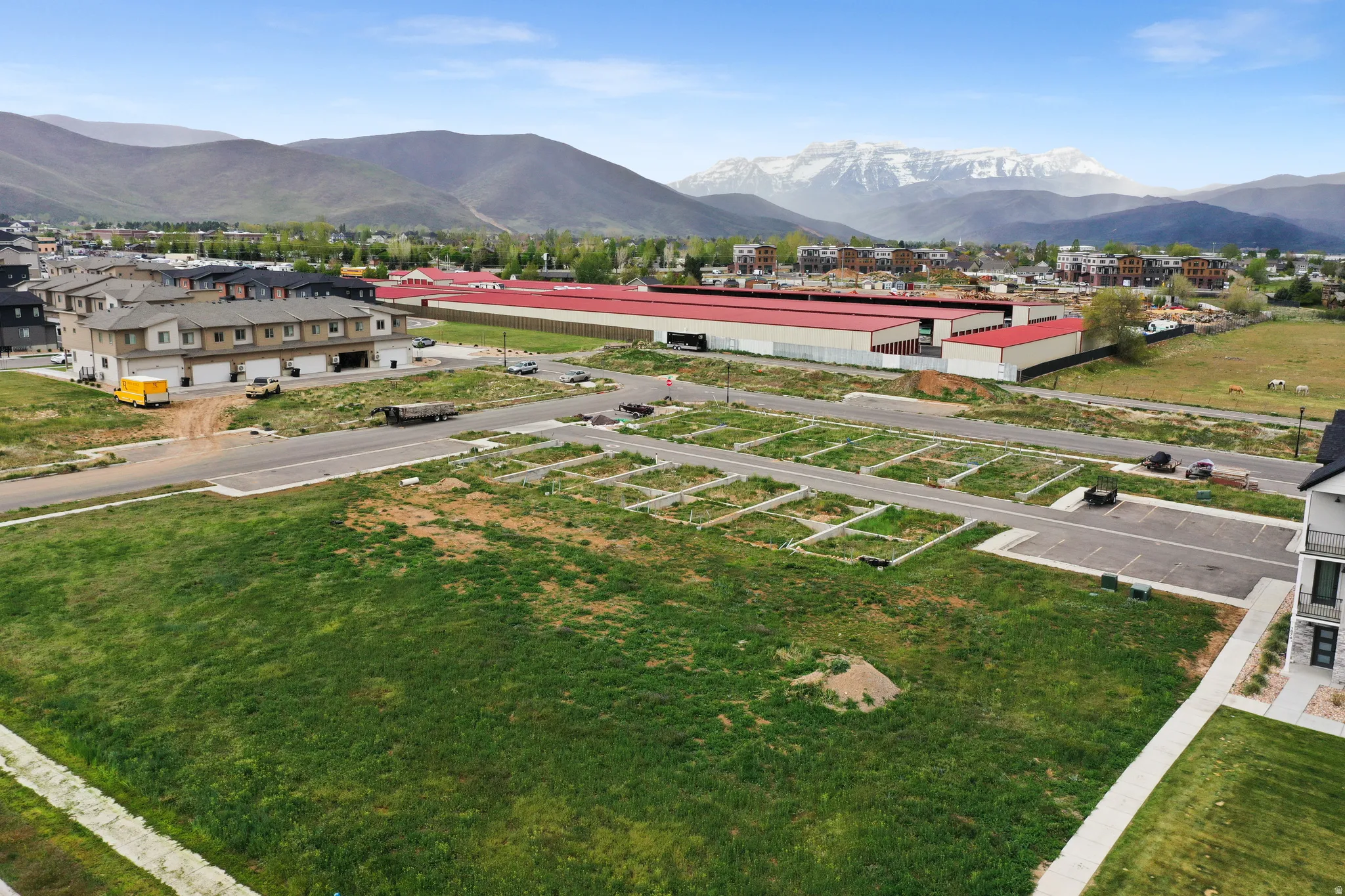 Expansive open lot featuring a green space and paved roads