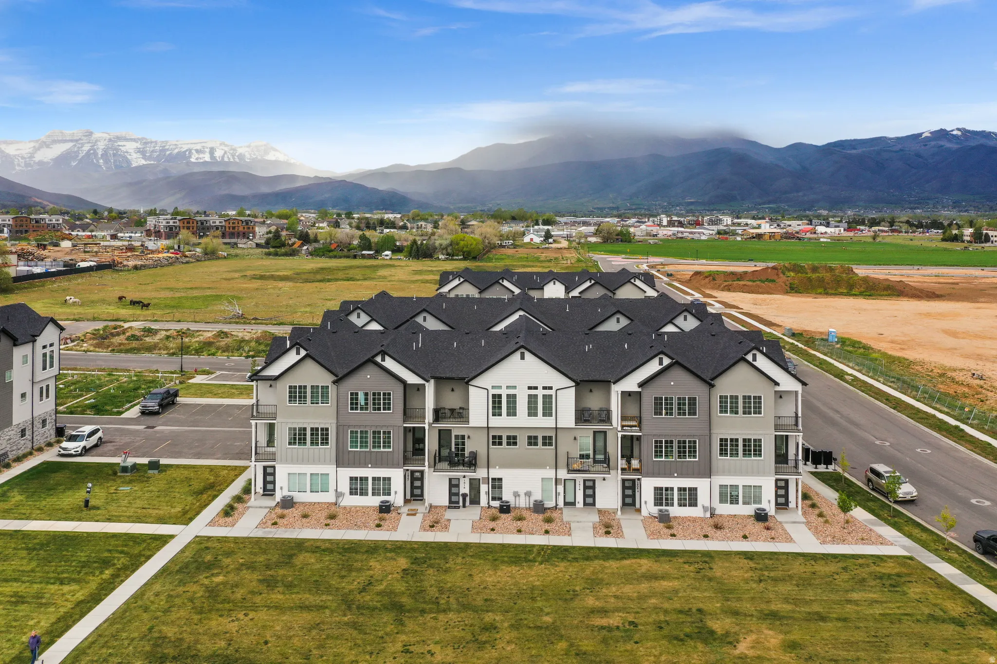 Contemporary townhome-style residences featuring multi-level construction, private balconies, and a distinctive dark-pitched roofline