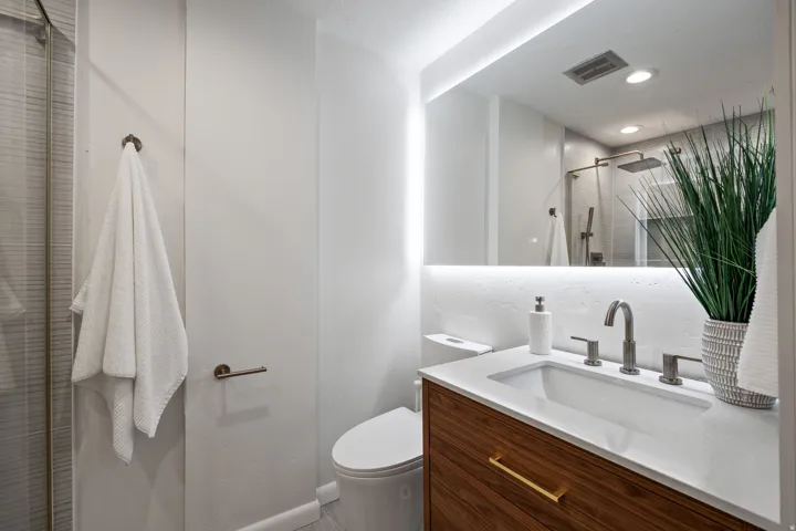 Modern bathroom featuring a wood-finish vanity with an integrated sink and brushed nickel faucet