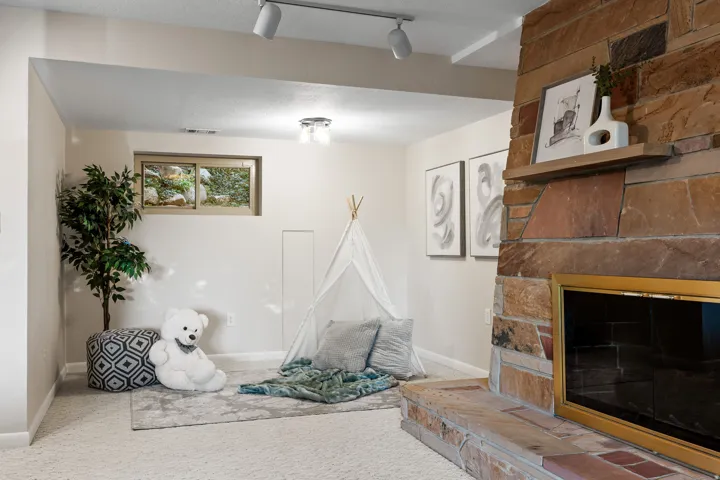 Stone-clad fireplace with a brass firebox surround and a wood mantel shelf