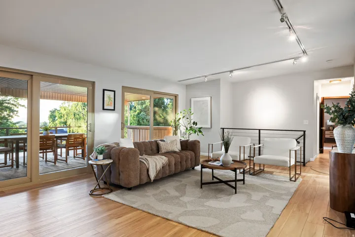 Bright living space featuring natural wood-finish flooring and track lighting