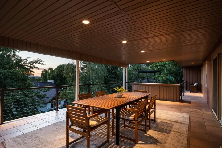 Expansive covered patio featuring recessed lighting, a cable railing system, and a wood-paneled ceiling