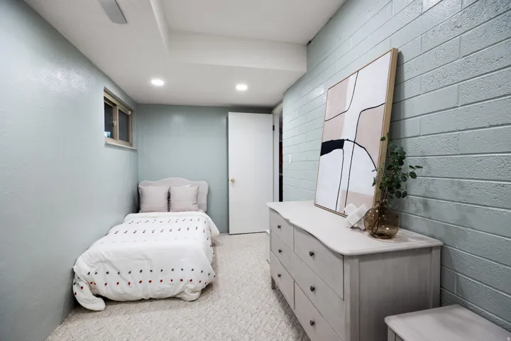 Room featuring light blue painted walls, one with a brick texture, and recessed ceiling lighting
