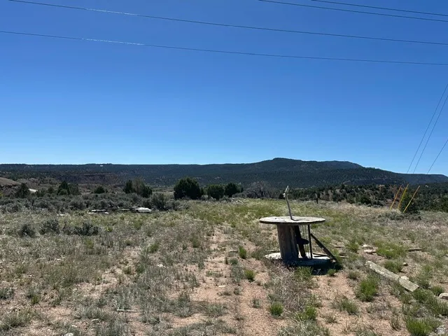 Expansive undeveloped land featuring natural terrain with scattered native vegetation and distant mountain ranges