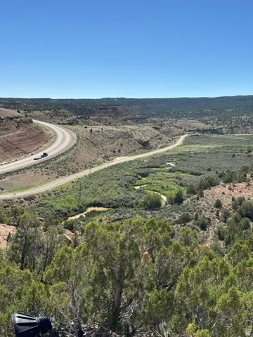 Expansive natural landscape featuring varied terrain, a winding riverbed, and natural foliage
