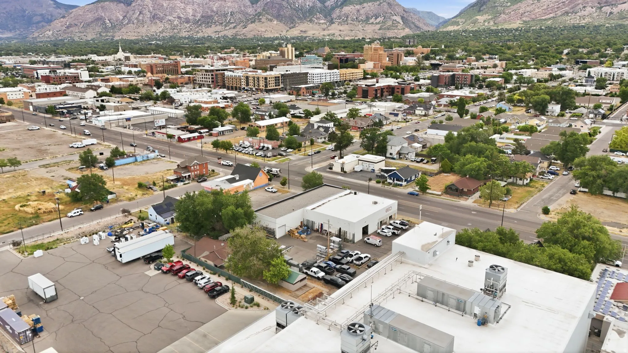 Expansive urban landscape featuring a mix of commercial and residential properties, framed by distant mountains