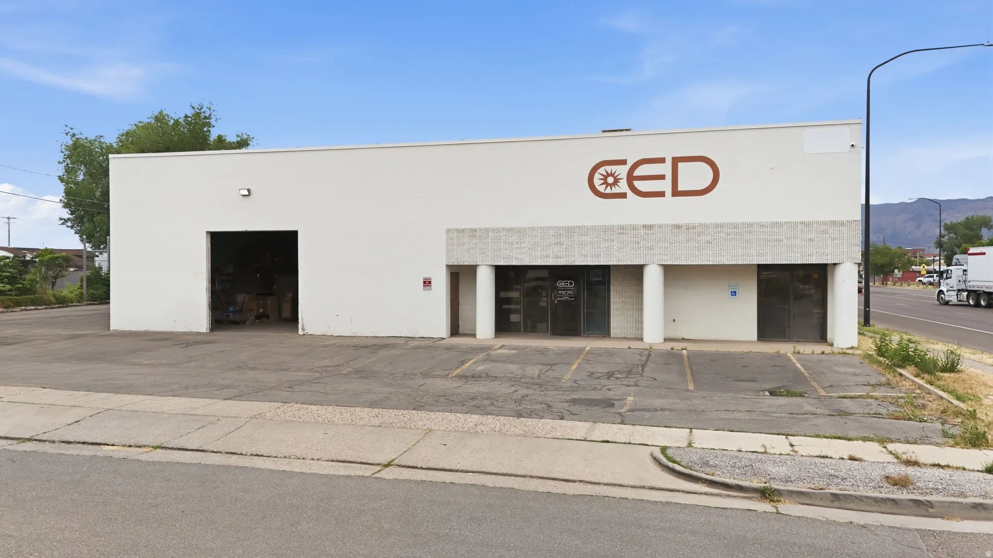 Commercial building featuring a white facade and a prominent drive-in bay