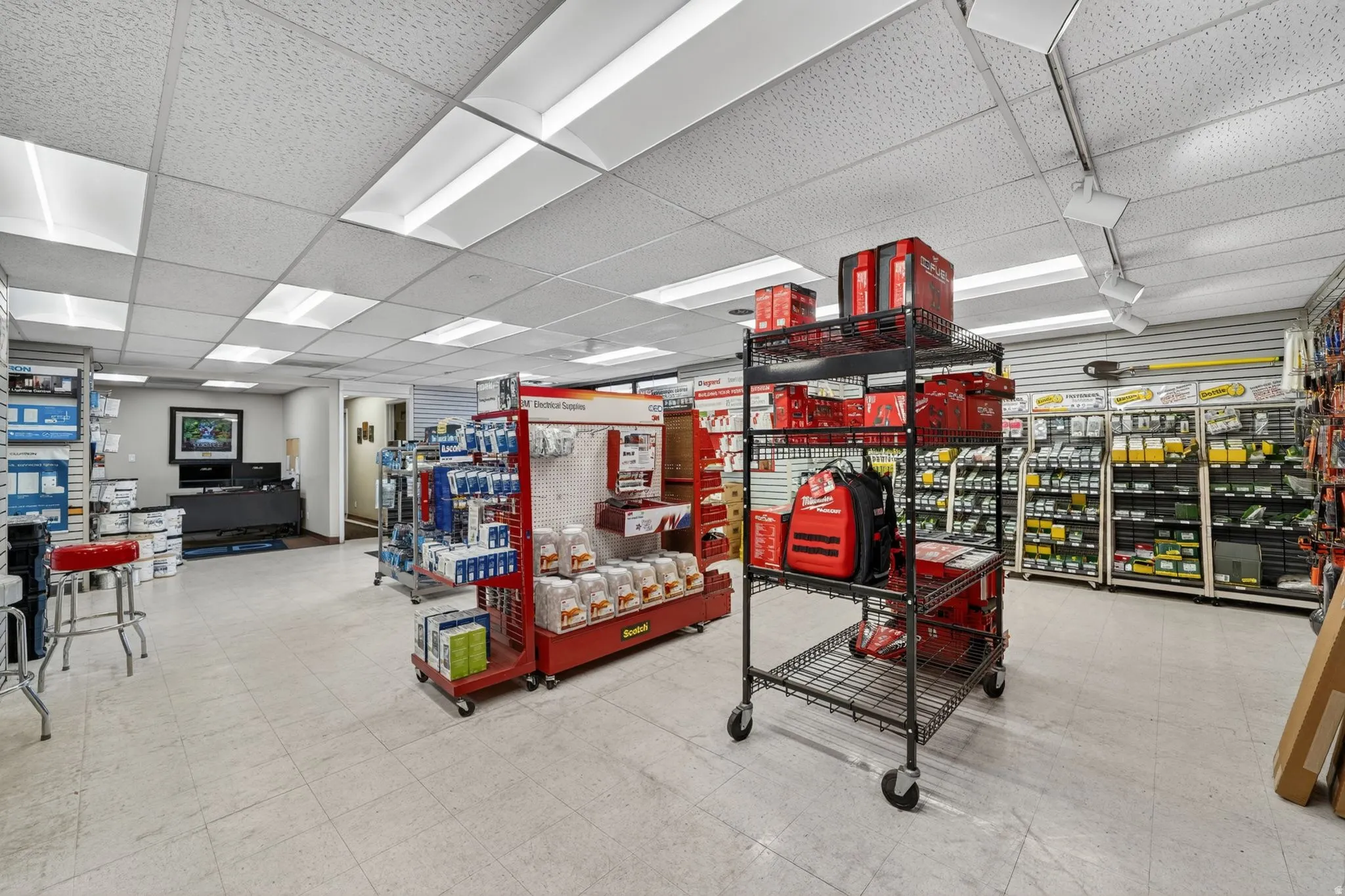 Commercial interior featuring extensive track lighting and suspended acoustic ceiling tiles