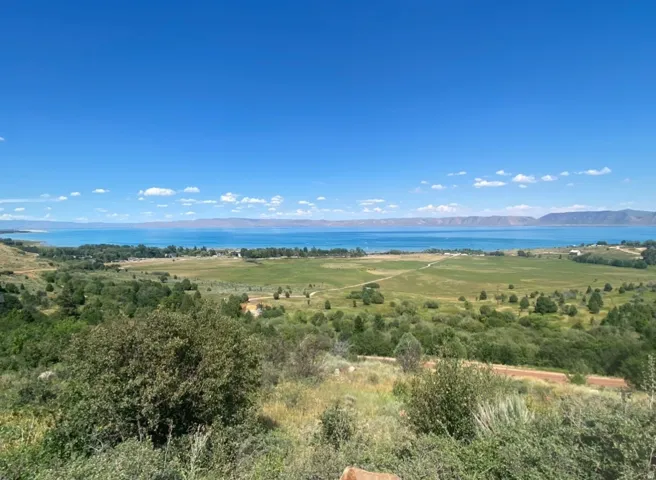 Expansive landscape featuring a large body of water under a clear blue sky