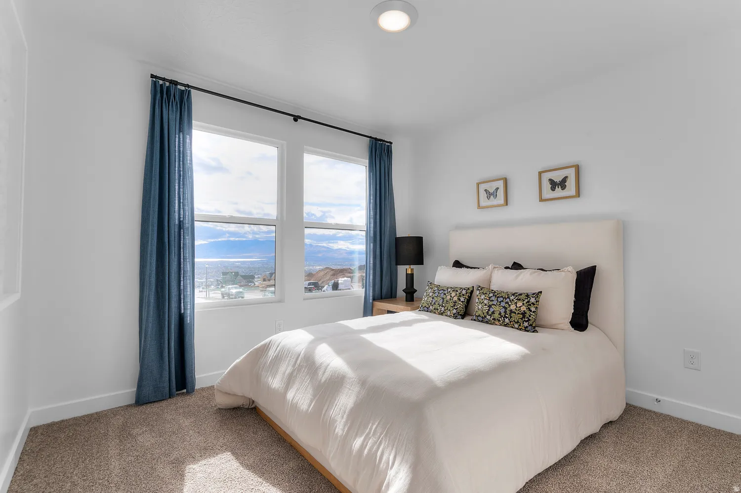 Bedroom featuring white walls, carpet flooring, and a pair of windows