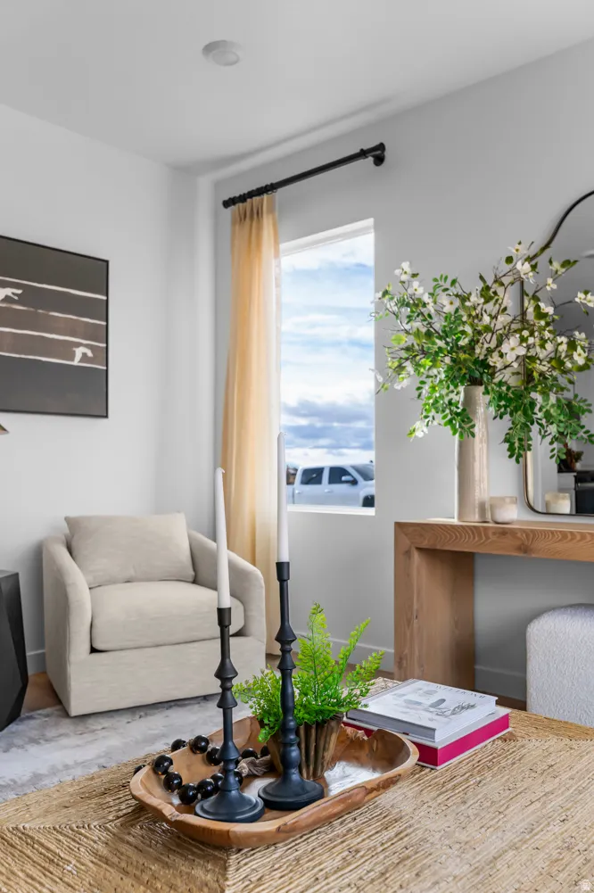 Bright interior space with a window featuring a black curtain rod and sheer curtain panel