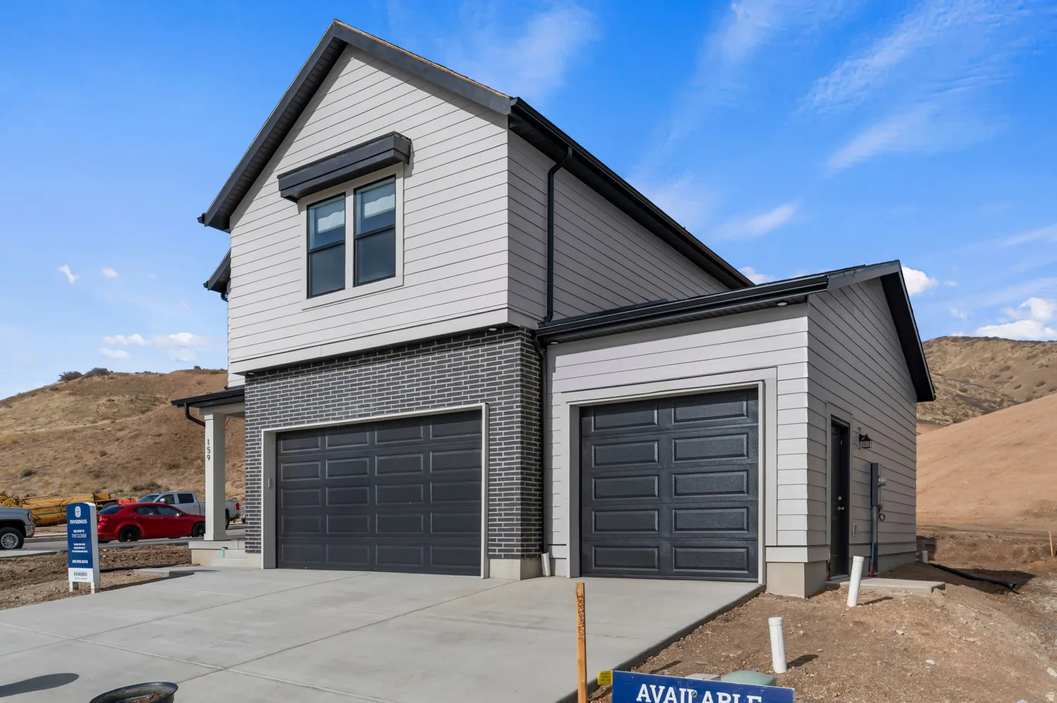 Modern two-story residence featuring light gray horizontal siding and a dark gray brick facade