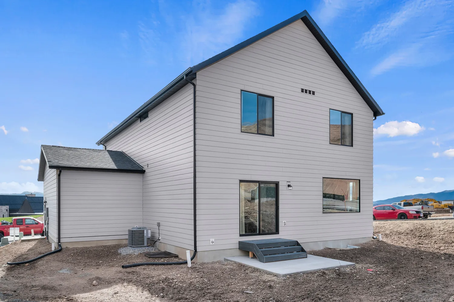 Contemporary exterior featuring light-toned horizontal siding and dark trim