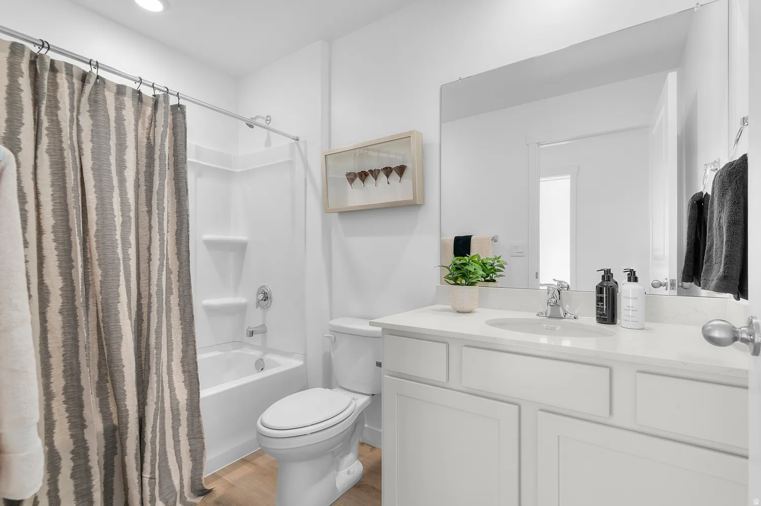 Bathroom featuring a single vanity with stone-finish countertop, undermount sink, and chrome faucet