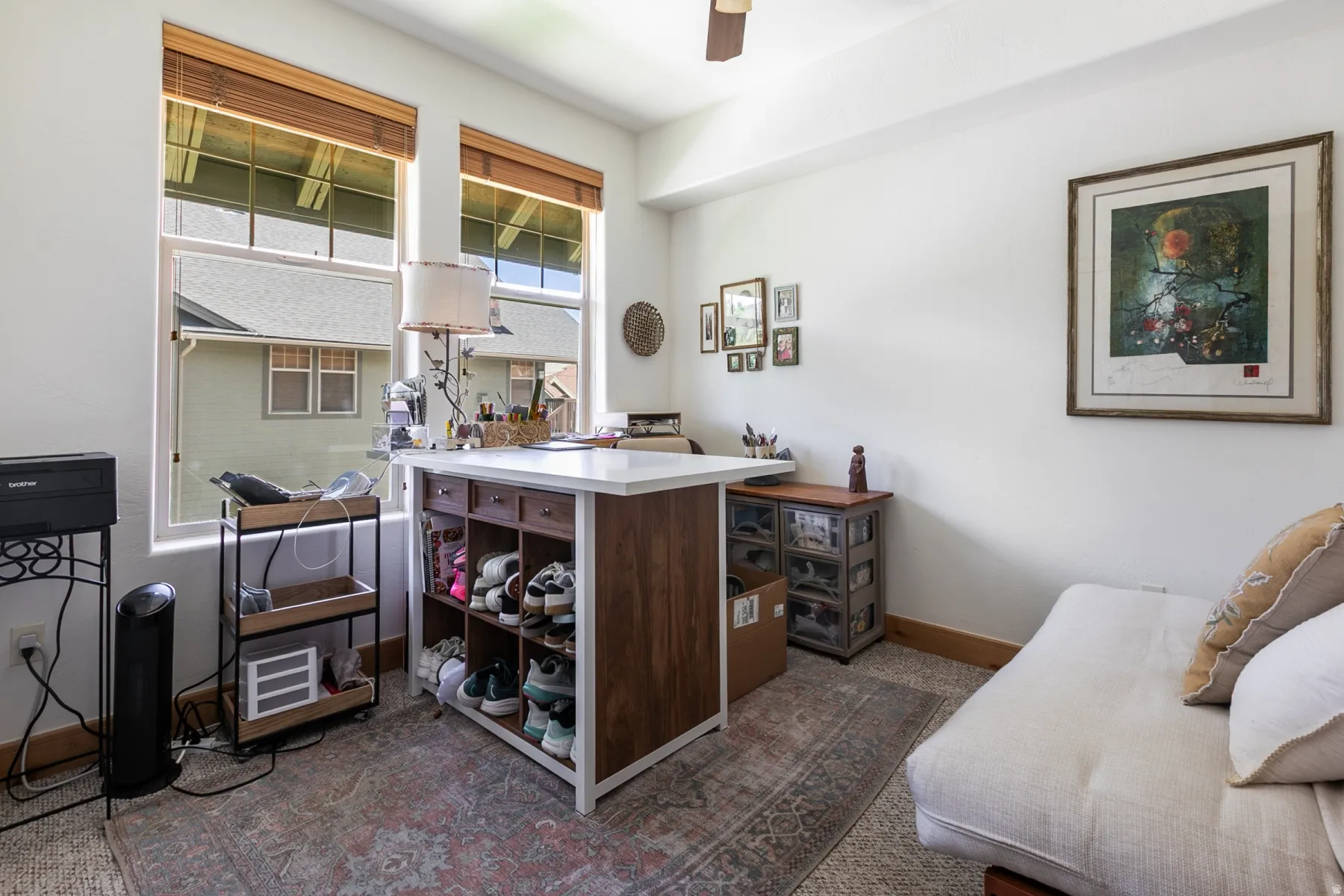 Bright room featuring two large windows with wood blinds, white walls, and a ceiling fan