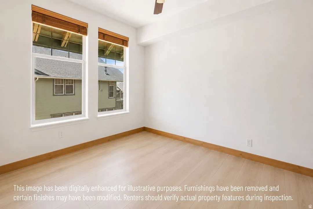 Bright room featuring two large windows with natural wood-tone blinds