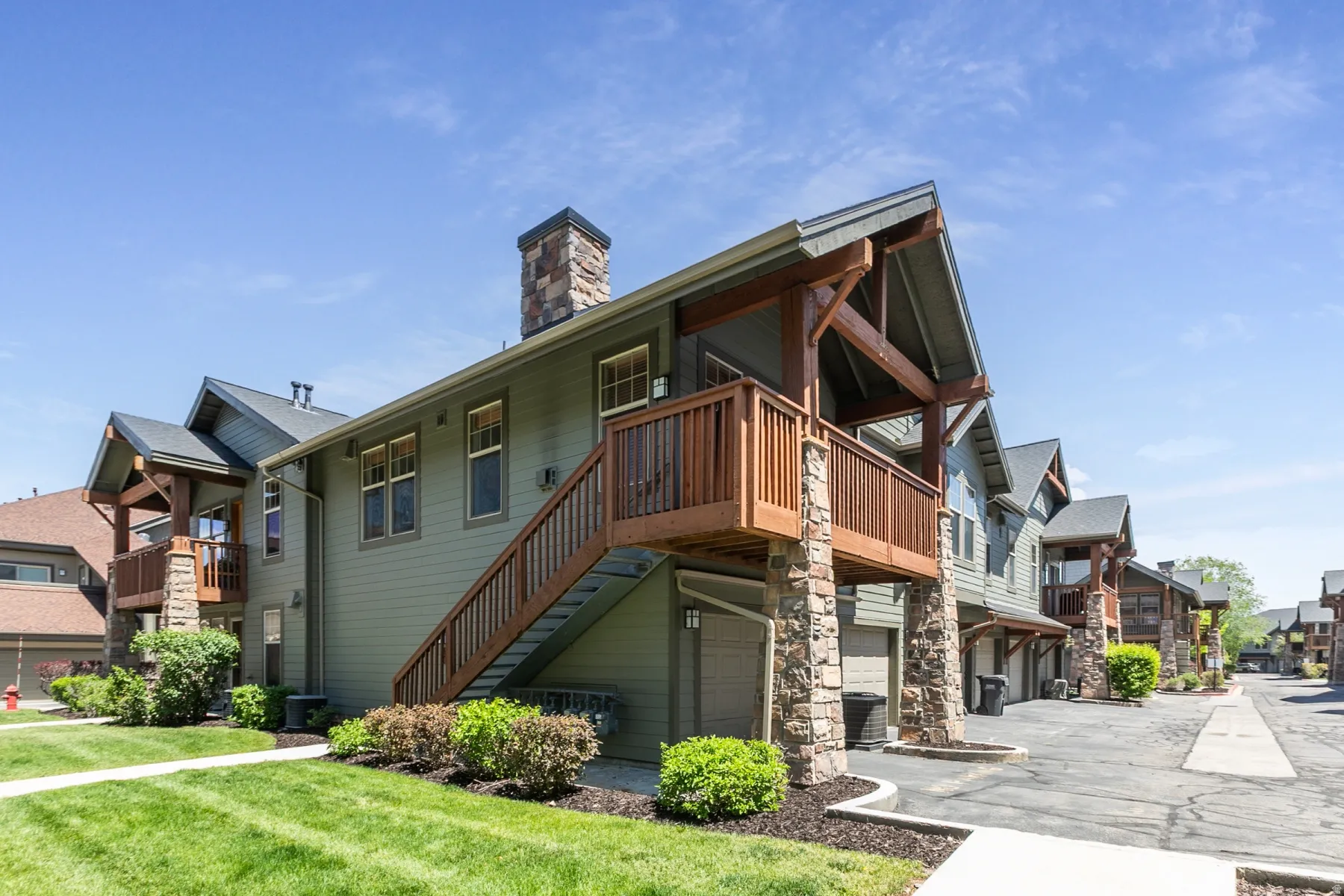 Multi-story building featuring green siding and stone accents