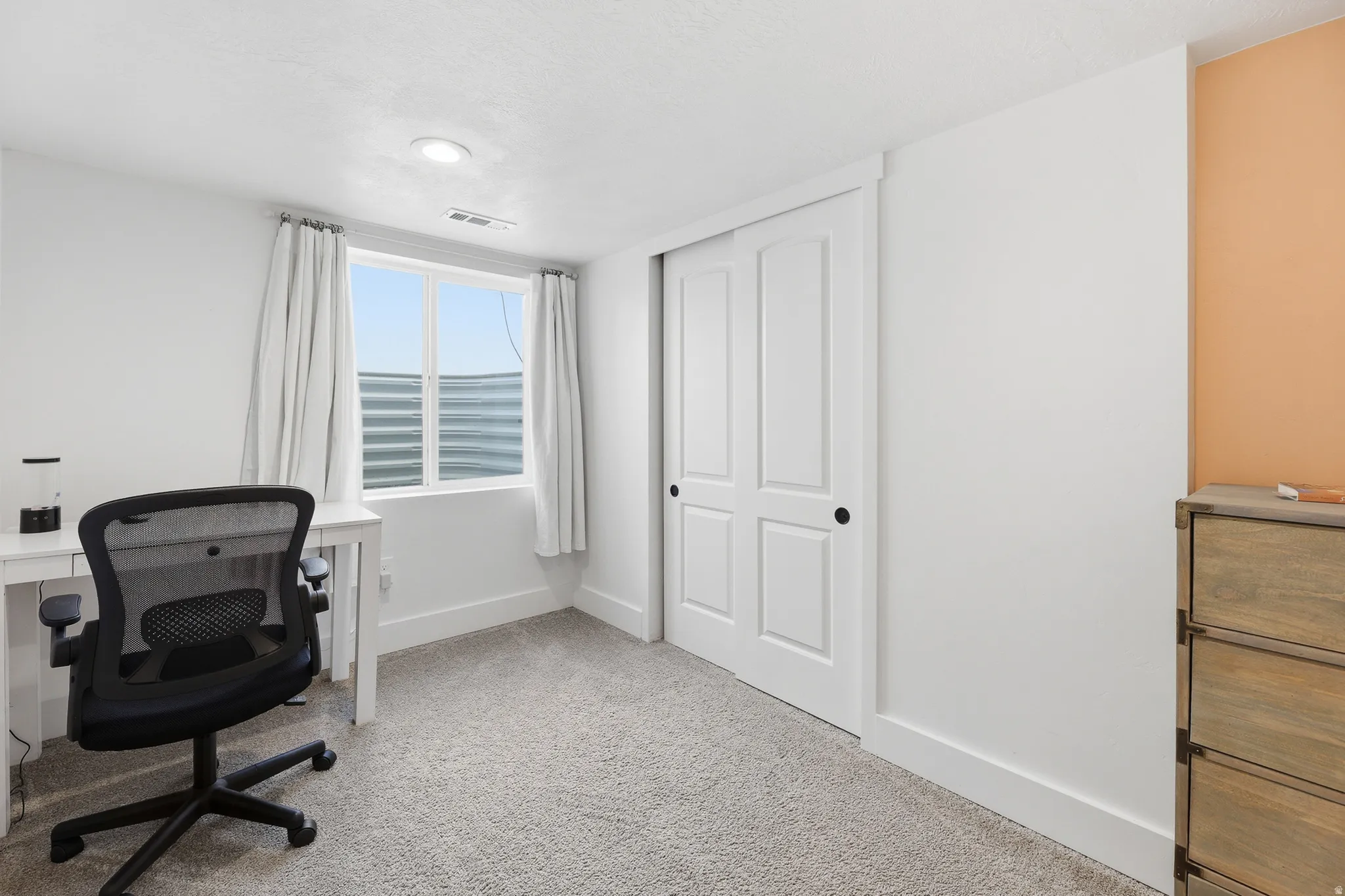 Room featuring light gray carpet flooring, white walls, and a recessed ceiling light