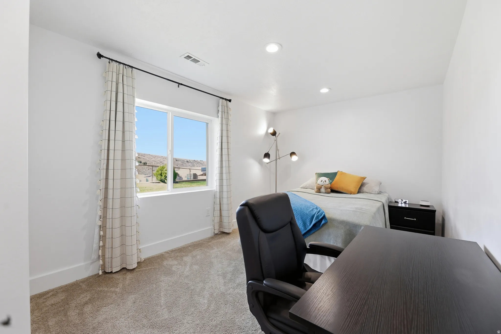 Spacious room featuring a large window, recessed lighting, and soft carpet flooring