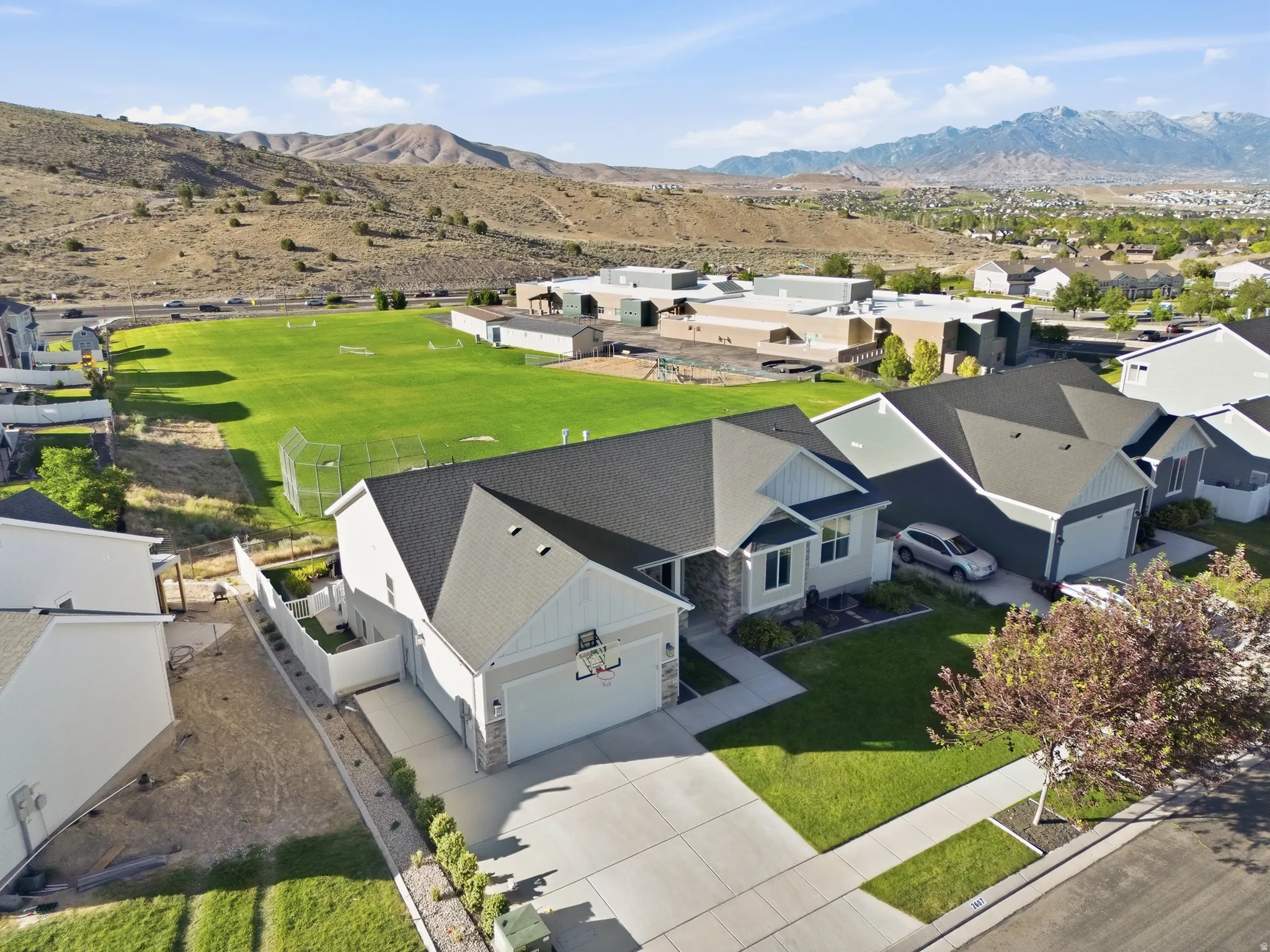 Modern single-story residence featuring a two-car garage, concrete driveway, and a manicured front lawn