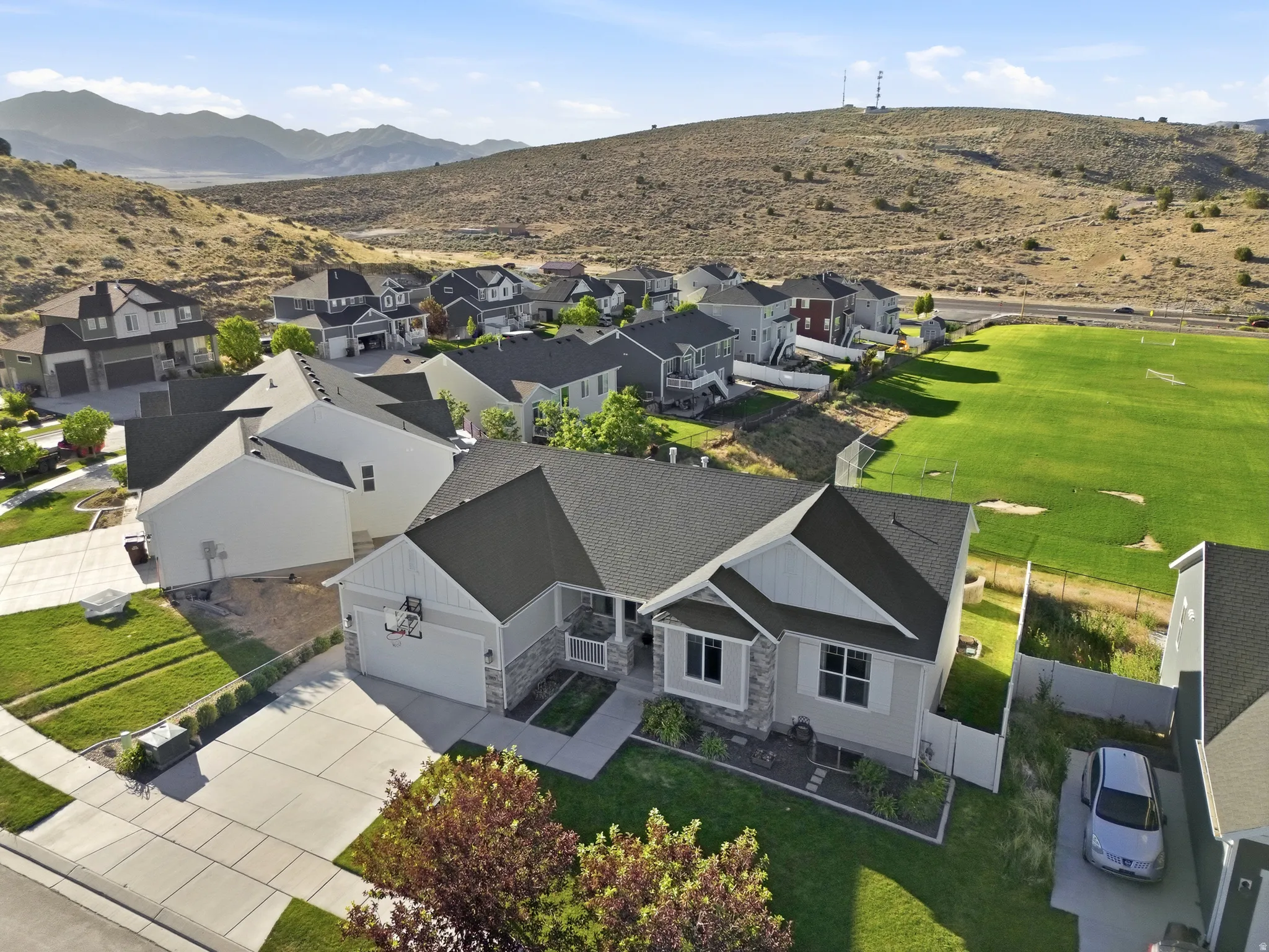 Contemporary single-story residence featuring light gray siding and stone facade accents