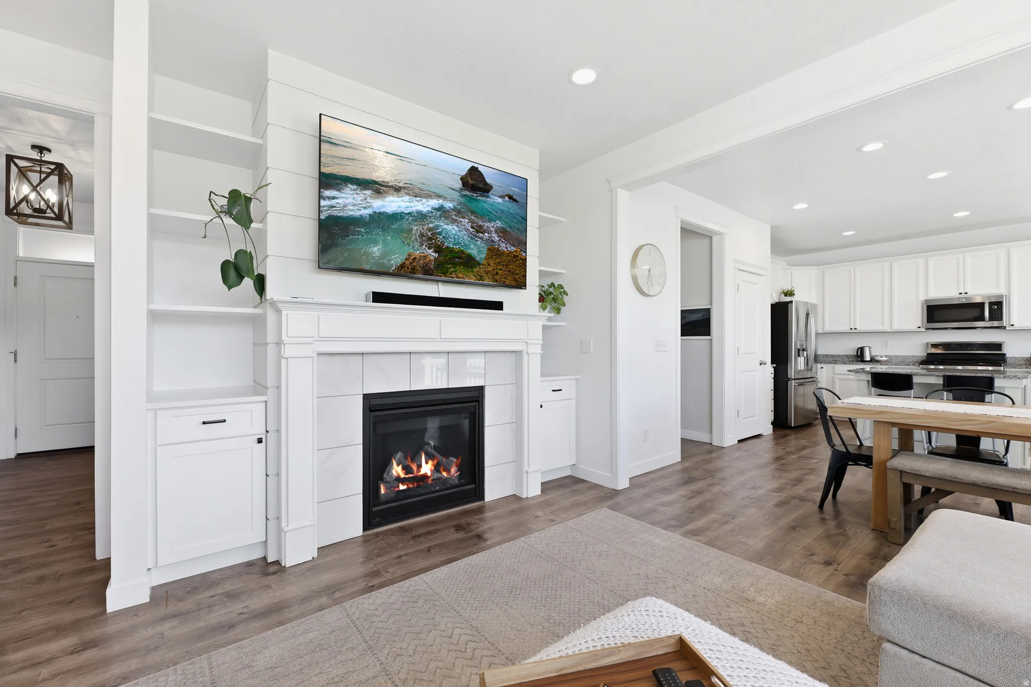 Living area featuring a fireplace with a white mantel and tile surround, flanked by built-in shelving and cabinetry