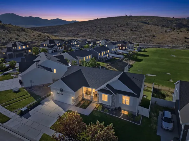 Contemporary ranch-style home featuring a stone and siding exterior, an attached two-car garage, and a covered front entry