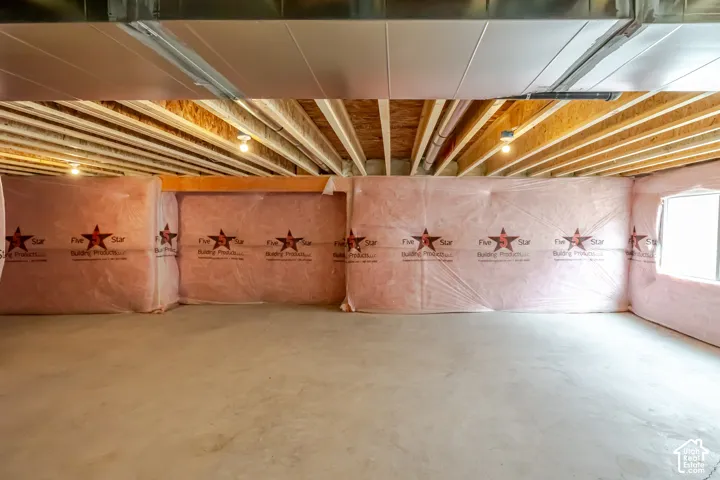 Unfinished lower level featuring exposed wood joist ceilings, concrete flooring, and insulated foundation walls