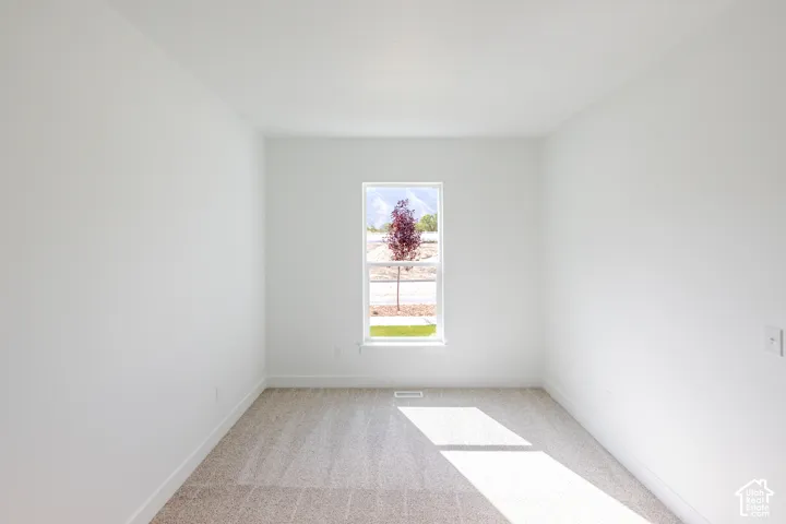 Interior room featuring neutral wall paint, wall-to-wall carpeting, and a single-hung window with exterior mountain scenery