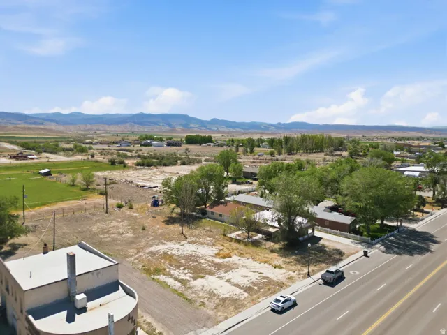 Expansive open land featuring diverse vegetation and distant mountains