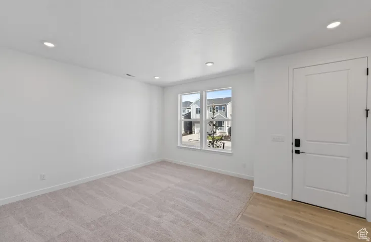 Carpeted living area featuring recessed lighting and a large window