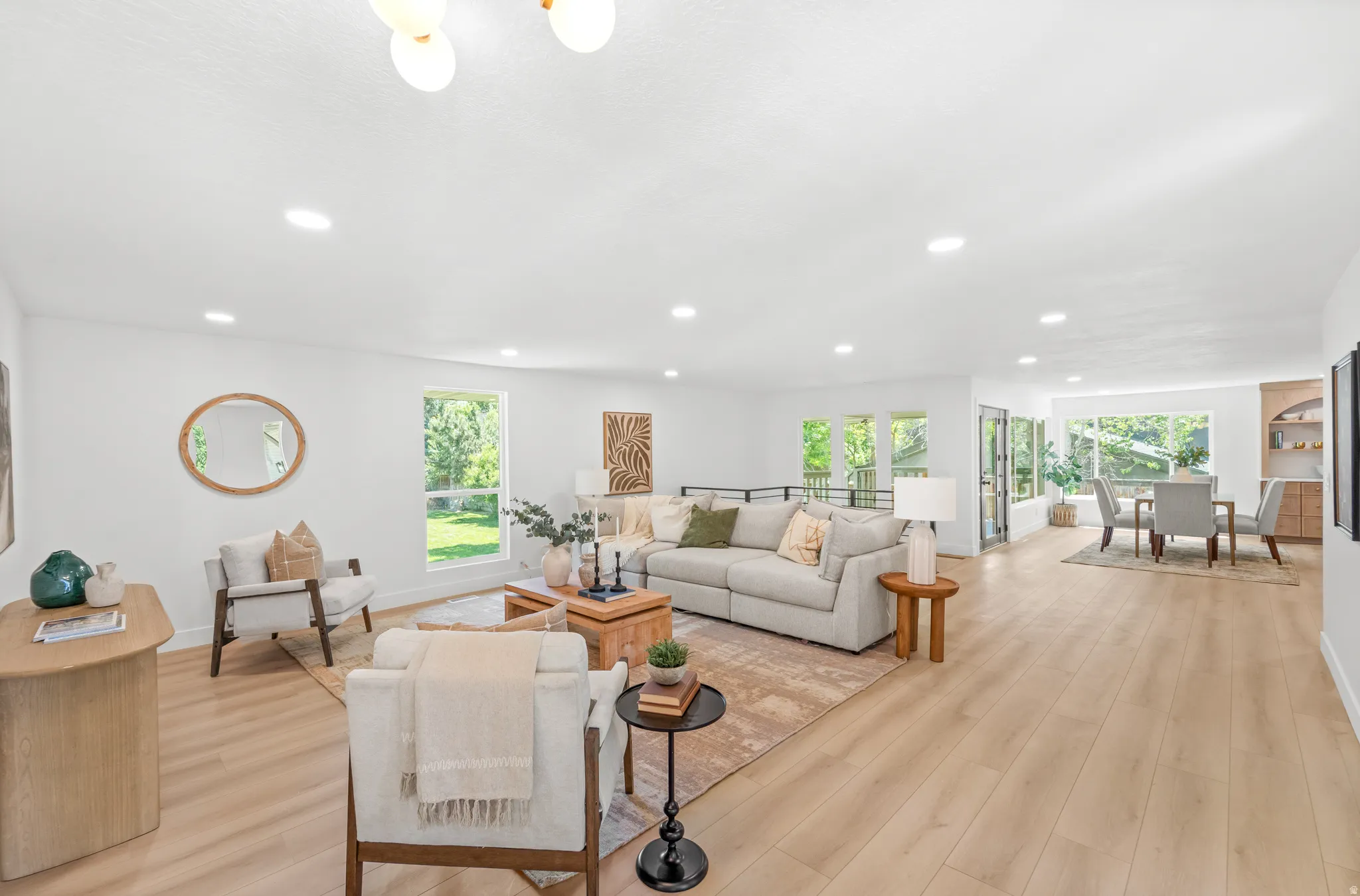 Spacious living area featuring light wood-finish flooring and recessed lighting
