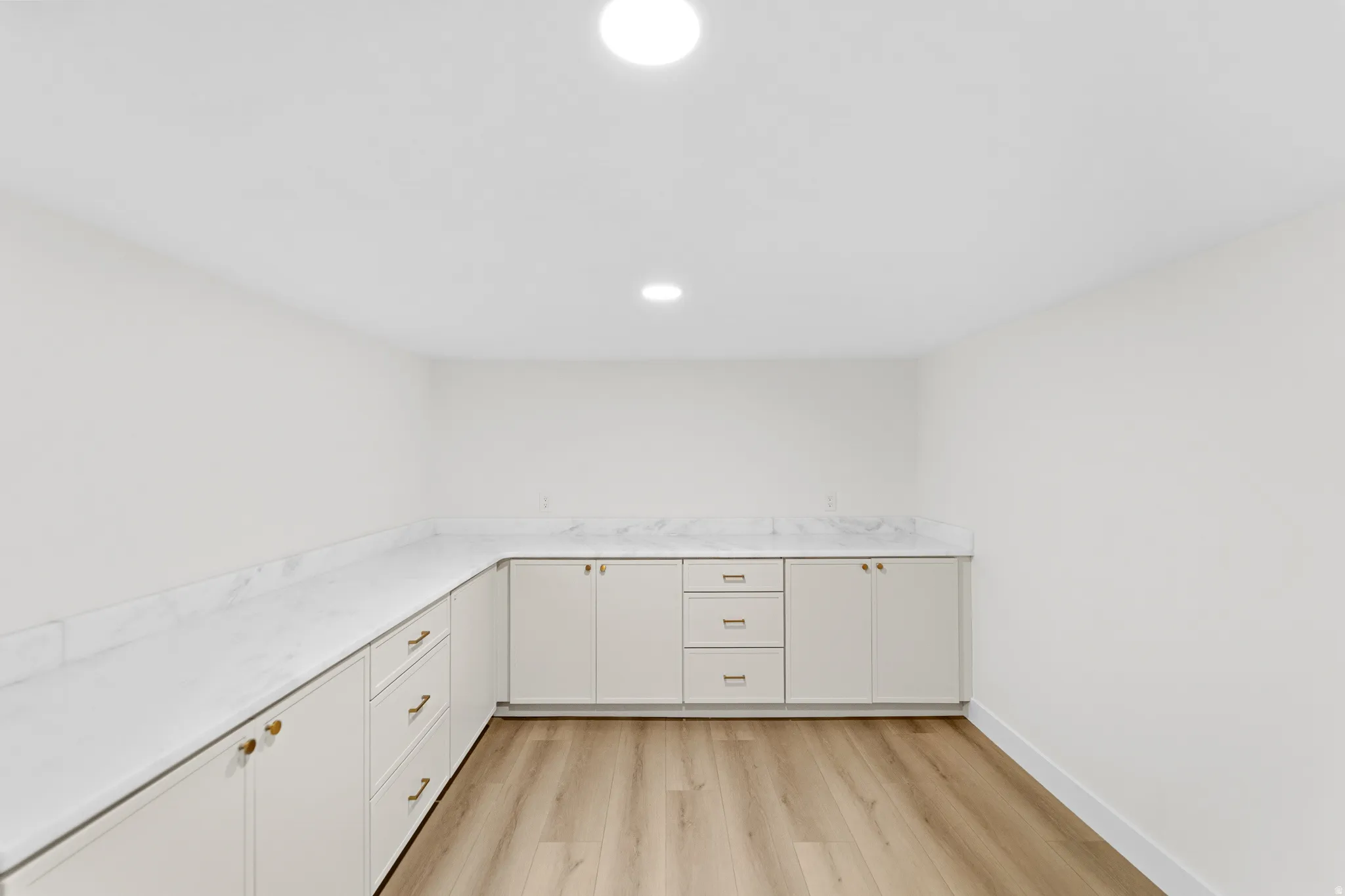 Expansive counter space featuring light stone-finish countertops and backsplash